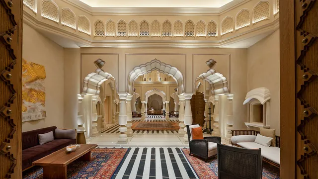 Ornate arched lounge with carved screens and a black-and-white floor